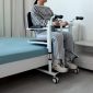 Adjustable-Patient-Lift-Near-Bed-and-Person-Sitting-on-It.jpeg