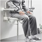 Person Sitting on Wall Mounted and Foldable Shower Chair