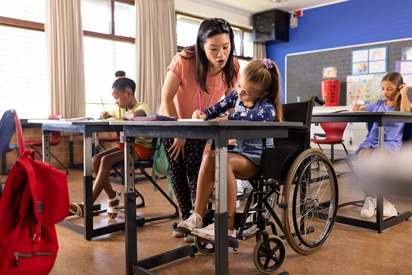 Teacher helping student on wheelchair