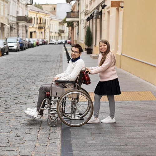 Girl helping man in wheelchair