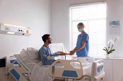 Community male-patient-bed-talking-nurse