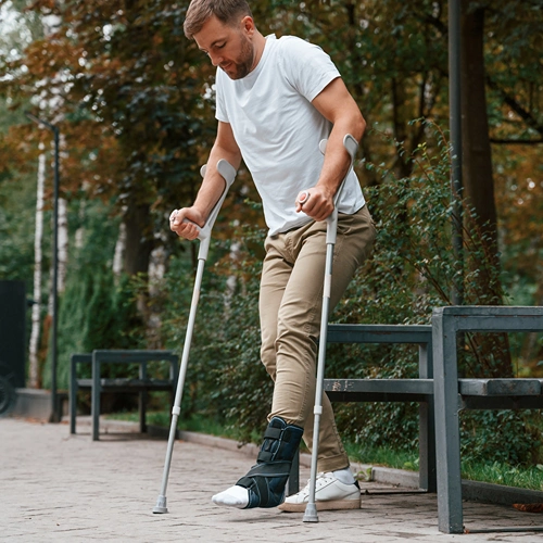 Injured man walking with crutches