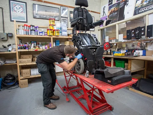 Man repairing electric wheelchair